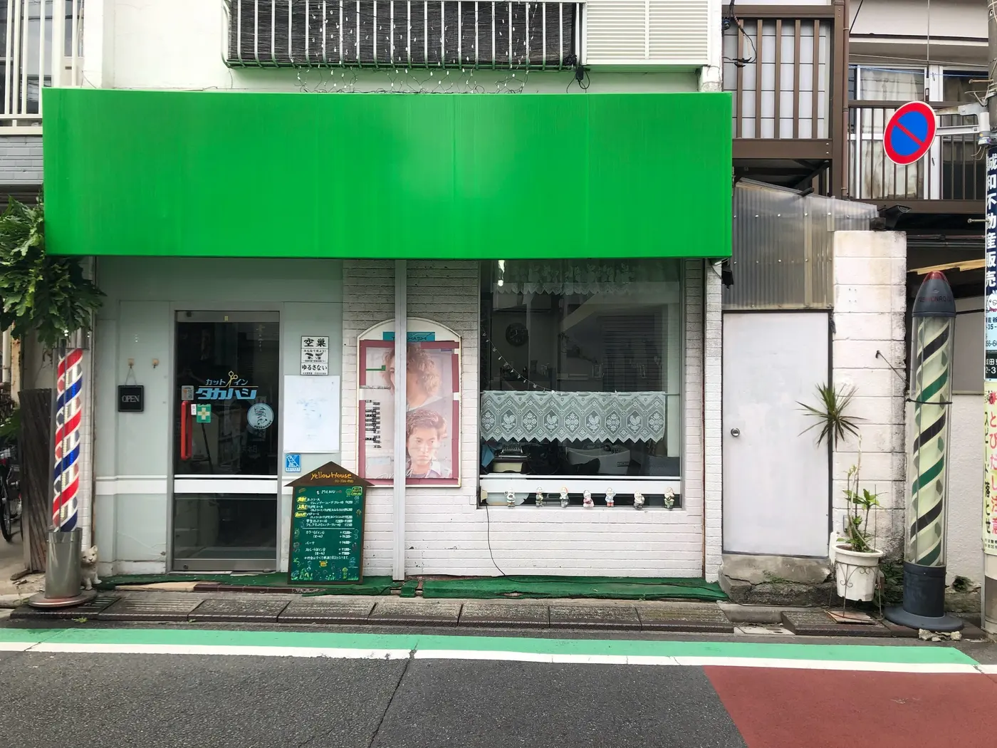 イエローハウスの外観。緑の看板とサインポールが目印です